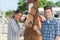 Woman and man standing beside horse