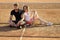 Woman and man tennis players with racket. Couple in love sit at tennis net on clay court