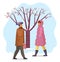 Woman and man in warm coat walking outdoor in cold winter weather near snowy tree with red berries