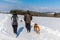 Woman and man on a winter walk. Man and woman hikers with dog on trekking in winter landscape. Active lifestyle. Winter landscape