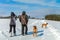 Woman and man on a winter walk. Man and woman hikers with dog on trekking in winter landscape. Active lifestyle. Winter landscape