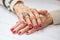 Woman manicured hands on table.