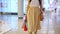 Woman with many colorful paper bags enjoying great shopping day in mall