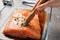 Woman marinating raw salmon in dish