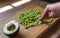 Woman mashing avocado with a fork on a wooden board