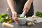 Woman mashing pesto sauce in mortar at table