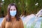 Woman in mask because of air pollution and epidemic in city. Protection against virus, infection, exhaust and industrial emissions