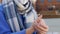 Woman in mask applying hand sanitizer outdoors