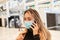 Woman with mask because of Covid-19 is on the phone with smartphone