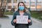 Woman in mask holds sign lost my job. Concept of job loss due to COVID-19 virus pandemic