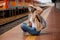Woman in a mask on the platform near the train. The girl is sitting at the train station near the train. Travel by rail. View of a
