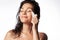 Woman massaging face by gua sha quartz stone scraper for skincare