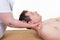 woman masseur doing neck massage on man in spa