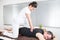 Woman masseuse performs a massage to a sporty man