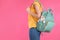 Woman with maternity backpack for baby accessories on color background, closeup.