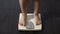 Woman measuring body weight on scales, healthy dieting, balanced nutrition