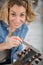 woman measuring guitar with metal ruler