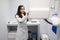 Woman in a medical coat adjusts a dental tomograph. Medical worker in the X-ray room.