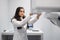 Woman in a medical coat adjusts a dental tomograph. Medical worker in the X-ray room.