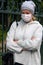 Woman in medical face mask with arms folded crosswise walking