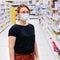 A woman in a medical mask chooses things in a supermarket. Sale of household goods and essential goods in the store. Being in