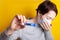 Woman in medical mask coughing with fever. Holds a thermometer in his hands. Severe condition of a coronavirus patient. Spread