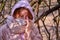 A woman in a medical mask is crying in depression while standing in a shelter, forest. Tourist hiding from quarantine of