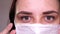 Woman with medical mask on her face. Close-up of woman`s eye. Concept of coronavirus epidemic or diseases.