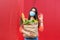 Woman with medical mask holding a shopping bag full of fresh food. Young woman with a grocery shopping bag during covid 19,