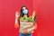 Woman with medical mask holding a shopping bag full of fresh food. Young woman with a grocery shopping bag during covid 19,