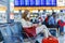 Woman with medical mask reading book and drinking coffee. Woman upset over flight cancellation, sitting in almost empty