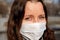 A woman in a medical mask walks alone on the street during the quarantine. Portrait of a female in a protective face mask against