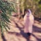 A woman in a medical mask walks along a path in a summer forest, selective focus. Concept of recovery from the flu virus pandemic
