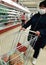 a woman in a medical mask walks around the supermarket, buying food. protection from the virus