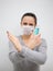 Woman in medical protection mask and sanitizer cross hands