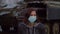 Woman in medical protective mask stands by military machine during pandemic outbreak of coronavirus COVID-19 and scared