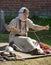 A woman in a medieval costume is engaged in needlework for the historical reconstruction of Vyborg Castle