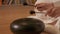 Woman meditates doing yoga playing on the steel tongue drum. Close-up.