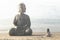 Woman meditates in front of the buddha statue in the middle of nature