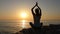 Woman meditates in the morning on the seashore