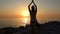 Woman meditates in the morning on the seashoreMorning meditation, woman practices yoga on the seashore