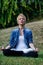 Woman meditates outdoors in a park or mountain