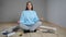 Woman meditates sitting on parquet among building materials