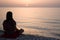 Woman meditating alone on the sea beach