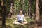 woman meditating alone and silent in summer forest