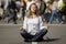 Woman meditating in busy urban street