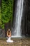 Woman meditating doing yoga between waterfalls