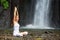 Woman meditating doing yoga between waterfalls