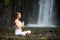 Woman meditating doing yoga between waterfalls