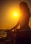 Woman meditating in lotus pose at sunset